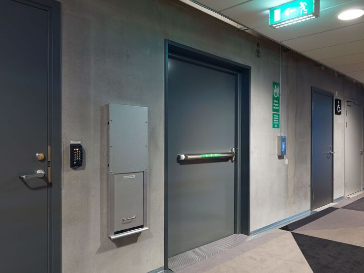 Grå säkerhetsdörr i korridor av betong